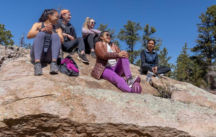 students sitting together on a large rock